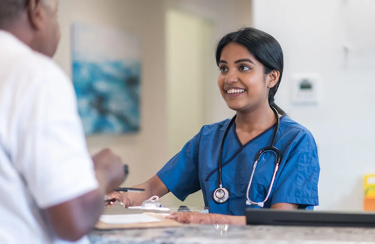 Female clinical medical assistant talking to male coworker