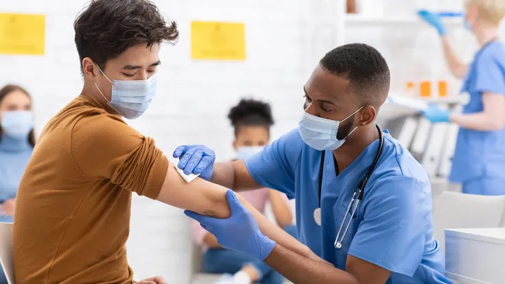 Male phlebotomy technician giving a Covid-19 Vaccination