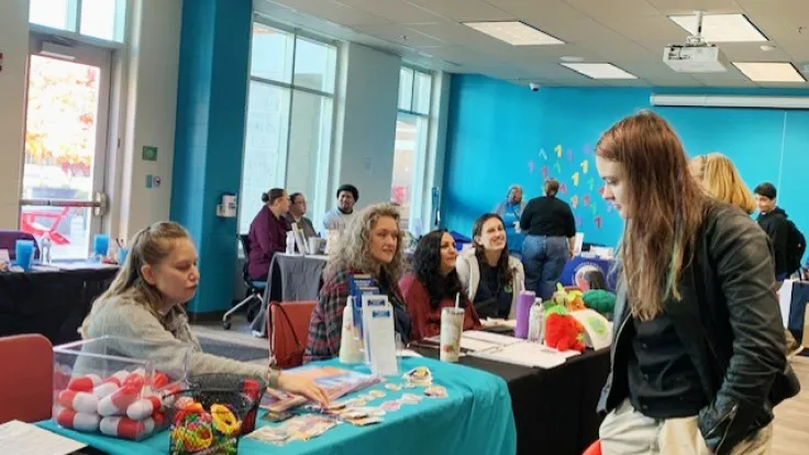 A student meeting with a community partner at last year's resource fair tables